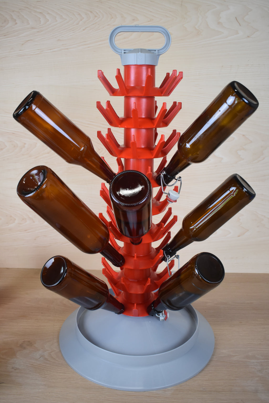 Red bottle tree with brown bottles on a wooden surface
